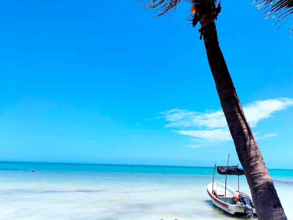 Bote a la orilla de un mar azul en Holbox